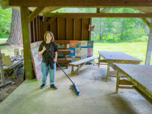 Child at work day sweeping the craft shed