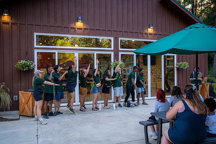 Camp staff raising their hands in front of the Dining Hall