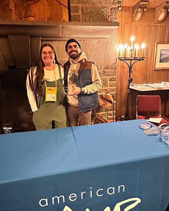 Outdoor School Director Marco holding an award from ACA staff member Jeanette