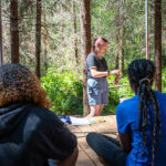 A staff member teaching campers about moss