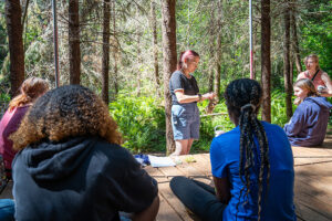 A staff member teaching campers about moss