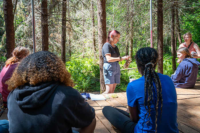 A staff member teaching campers about moss